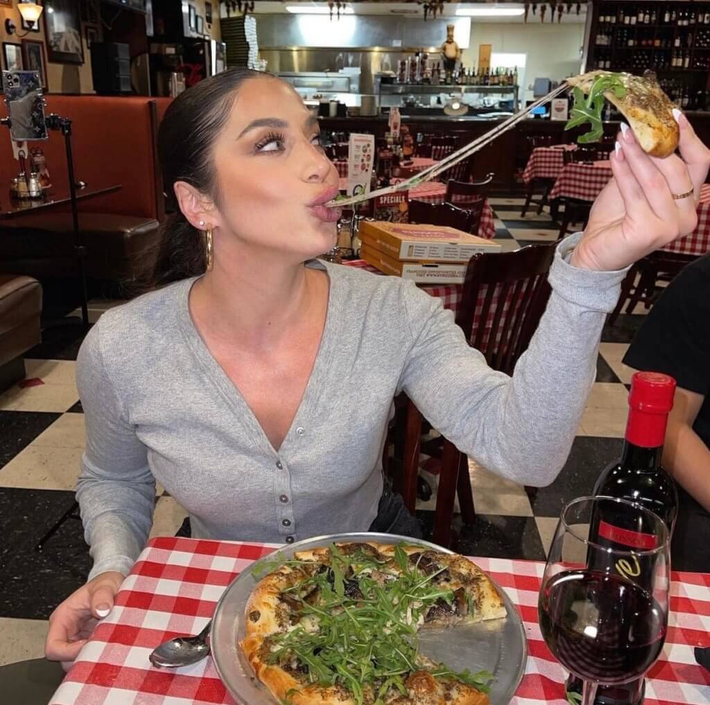 Woman Enjoying Eating Pizza at Russo's in The Woodlands