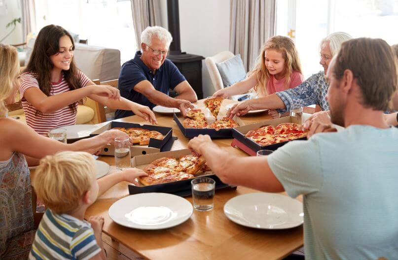 family around table with pizza