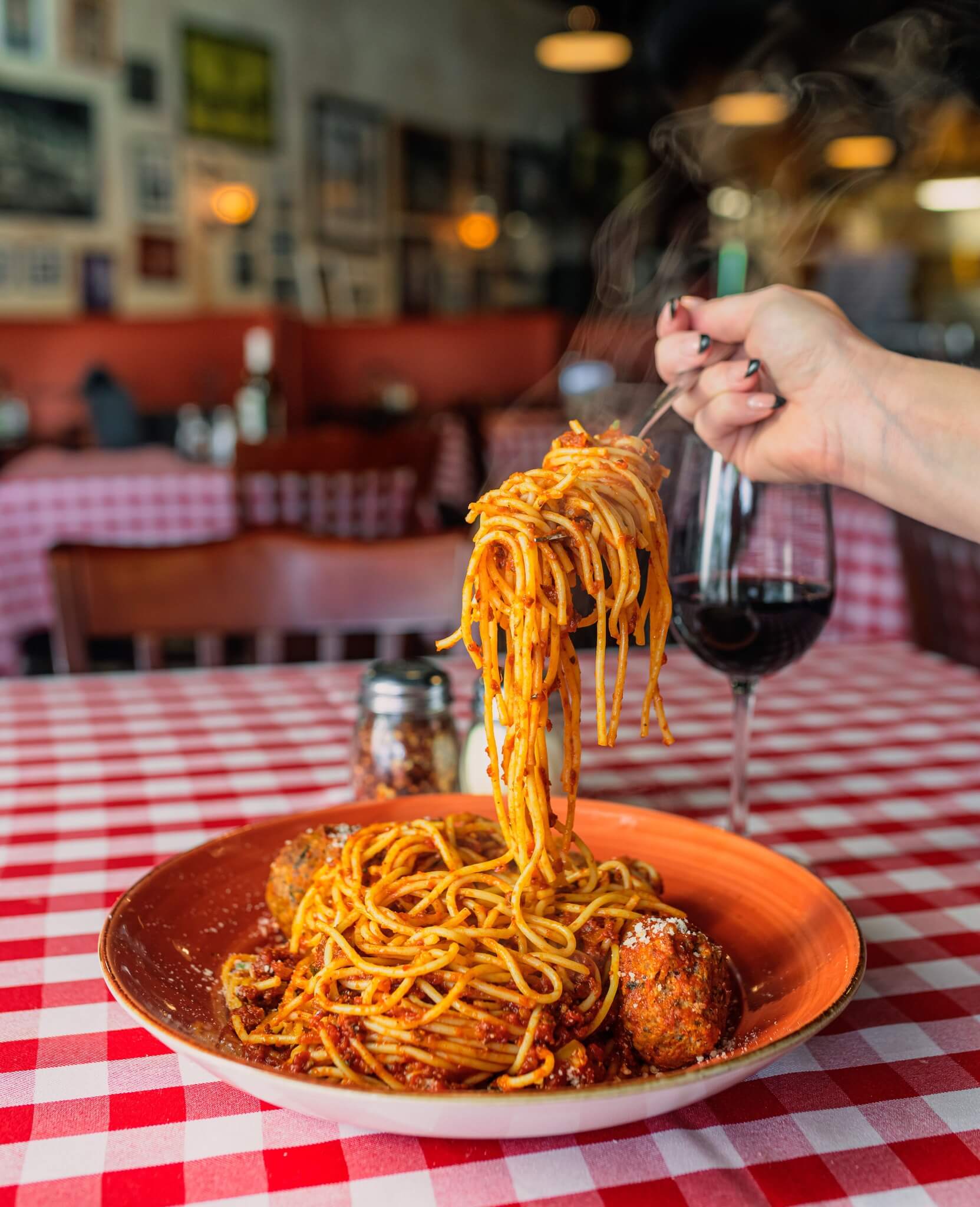 russo's spaghetti and meatballs with a glass of wine