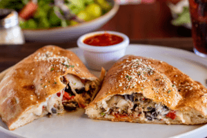 stromboli calzone cut in half on a plate